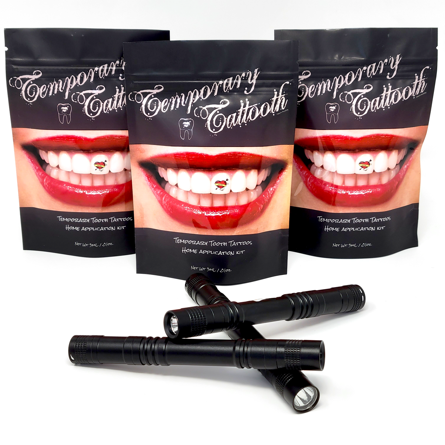 A photograph of three Temporary Tattooth Ultra Lights. There are also three Temporary Tattooth Home Application Kits in the background.