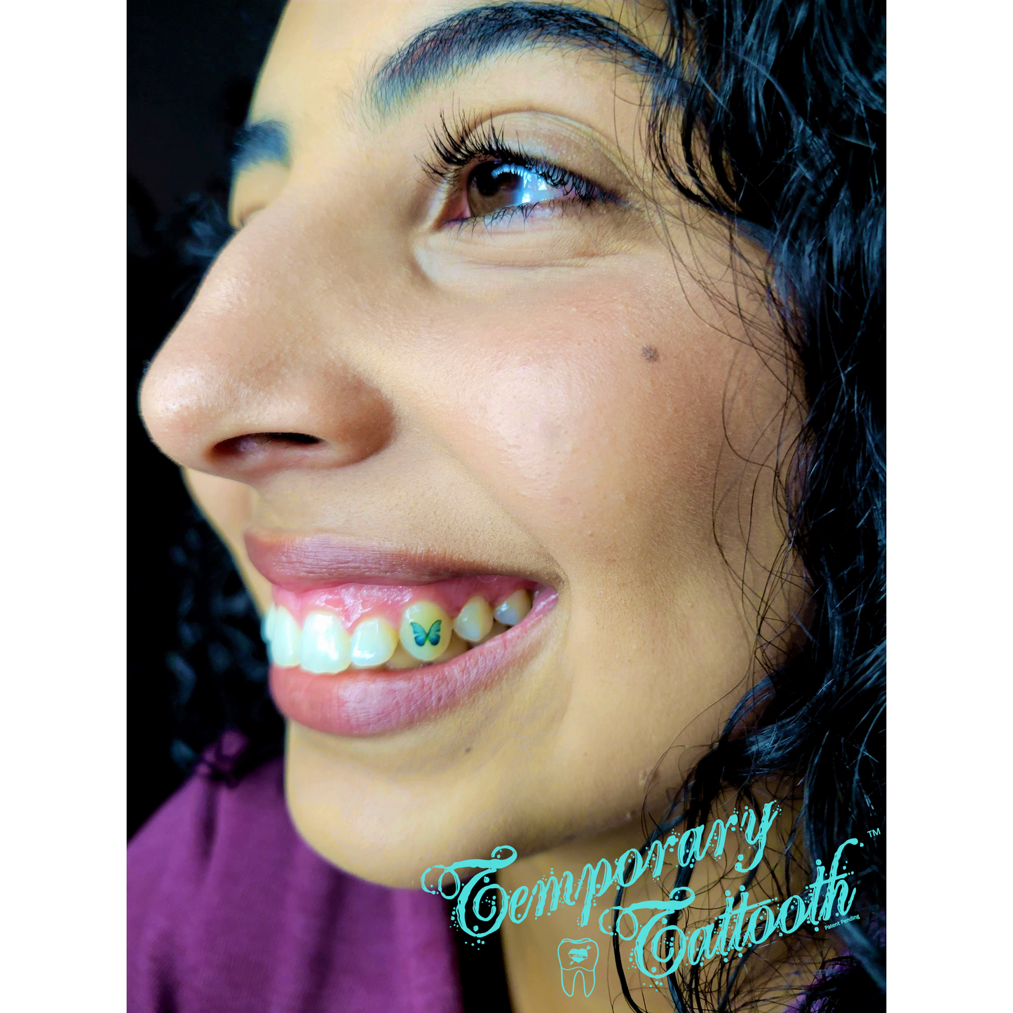 A photograph of a girl with a butterfly Temporary Tooth Tattoo, also known as a Temporary Tattooth. These tooth images can be applied at home with this kit.