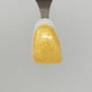 Fine Light Gold Sparkle Temporary Tattooth Colorant on a demo tooth.  These colorants can be applied to teeth to temporarily alter their color or iridescence.