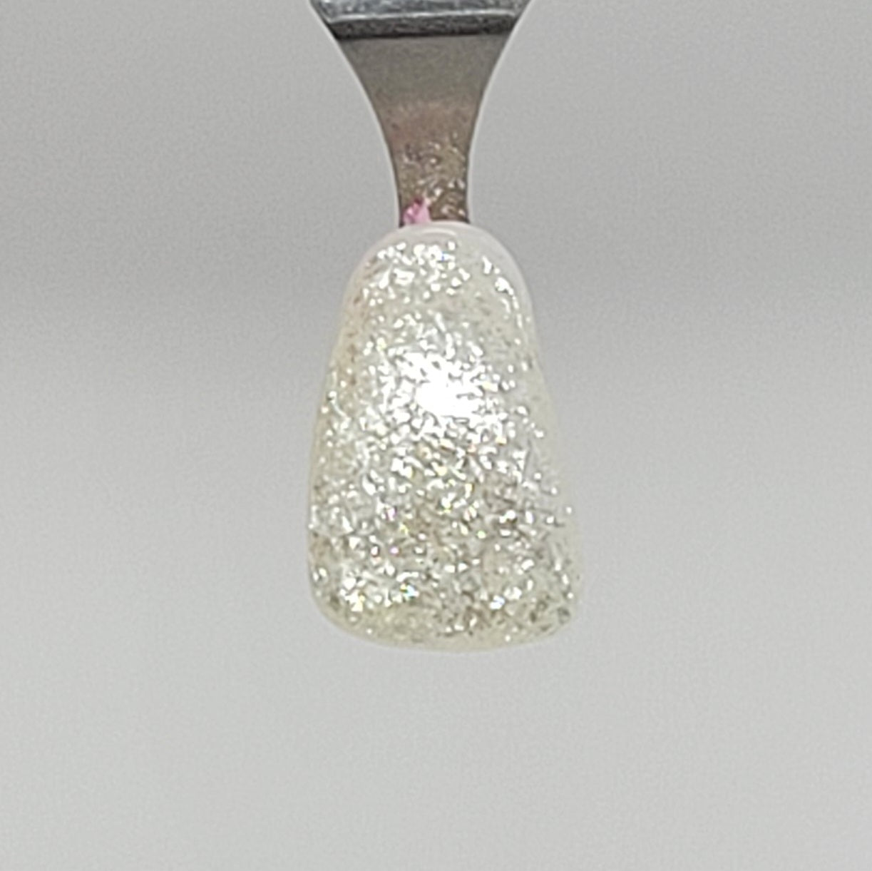 White Sparkle Temporary Tattooth Colorant on a demo tooth.  These colorants can be applied to teeth to temporarily alter their color or iridescence.