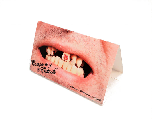 A photo stand of a Temporary Tattooth.  A flower temporary tooth tattoo on a unique smile.